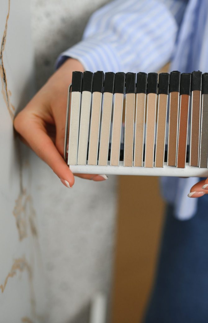 female interior designer choosing flooring tile color texture samples at store shop.